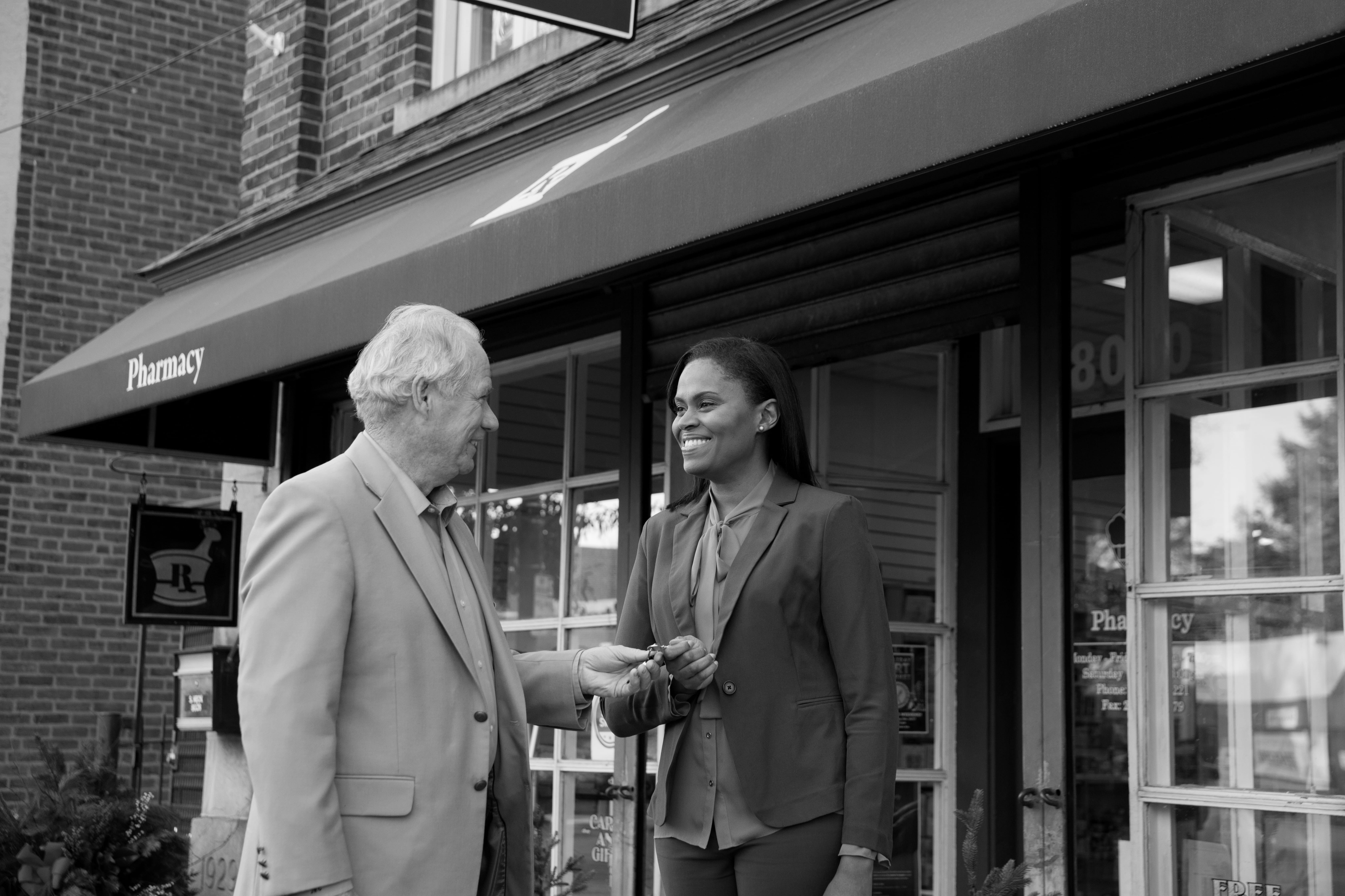 A pharmacy seller hands the keys over to the new owner