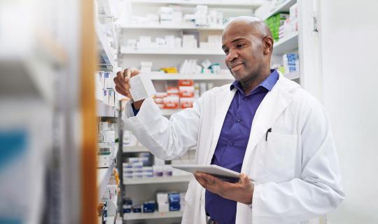 Cropped shot of a pharmacist using a digital tablet in a chemist