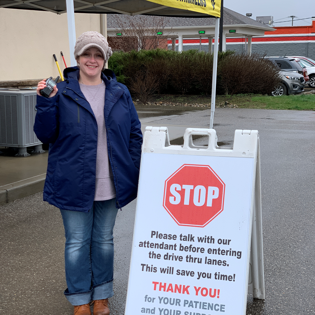 A staff member from Moundsville Pharmacy taking drive-thru orders outside to expedite transactions