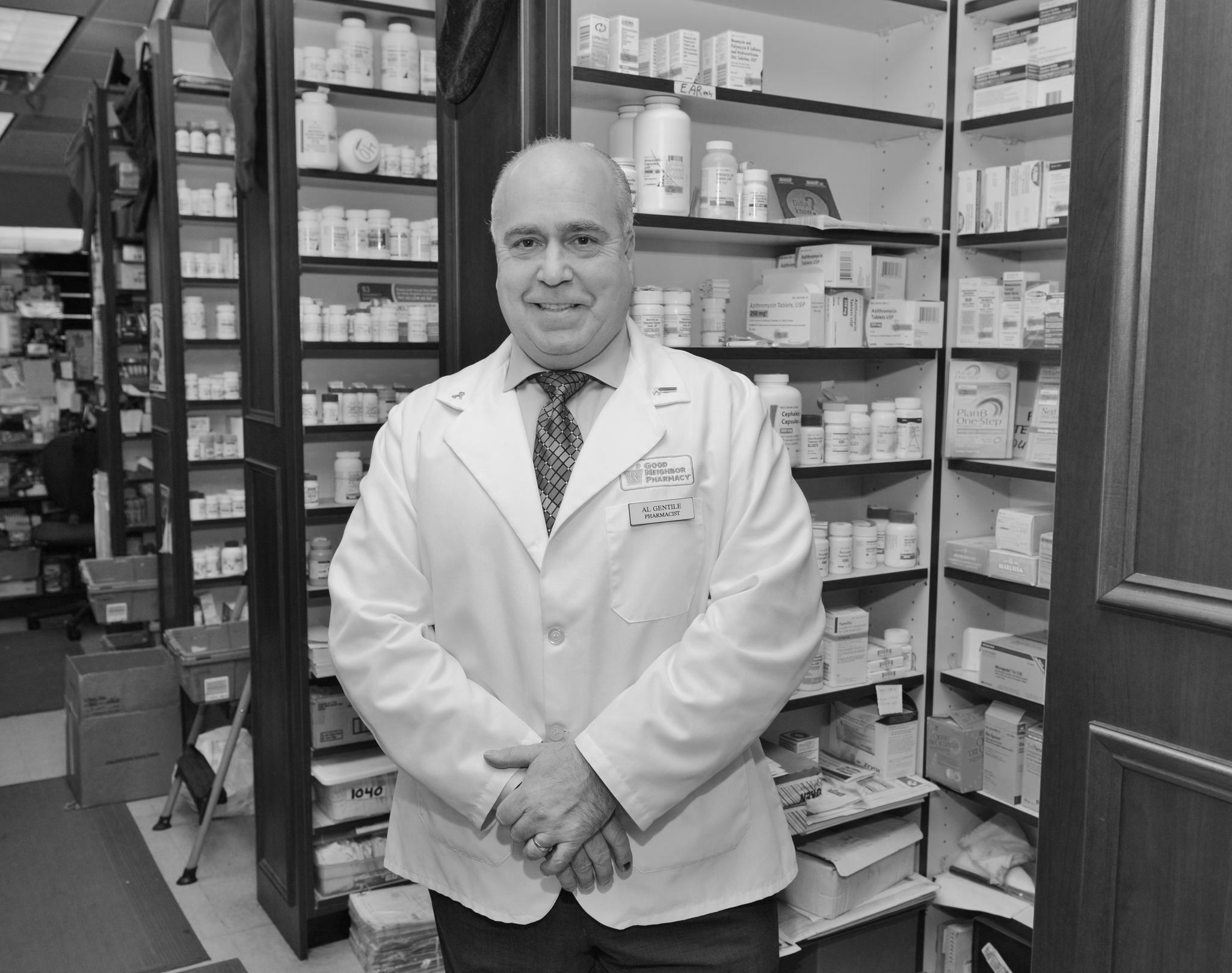 The owner of St. George Pharmacy standing behind the counter of his store