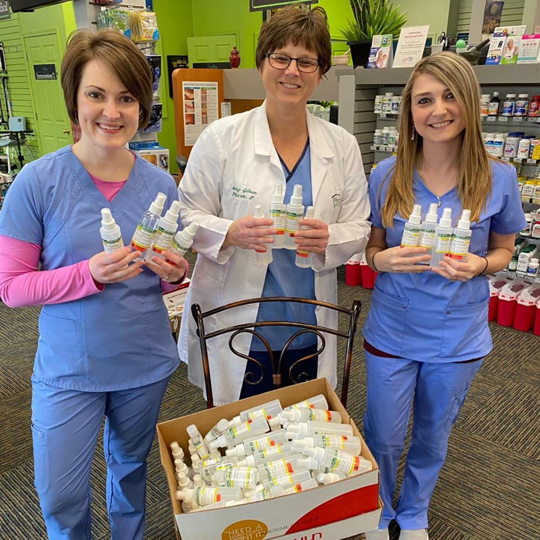 The Woodsprings Pharmacy team displays the hand sanitizer they compounded in house