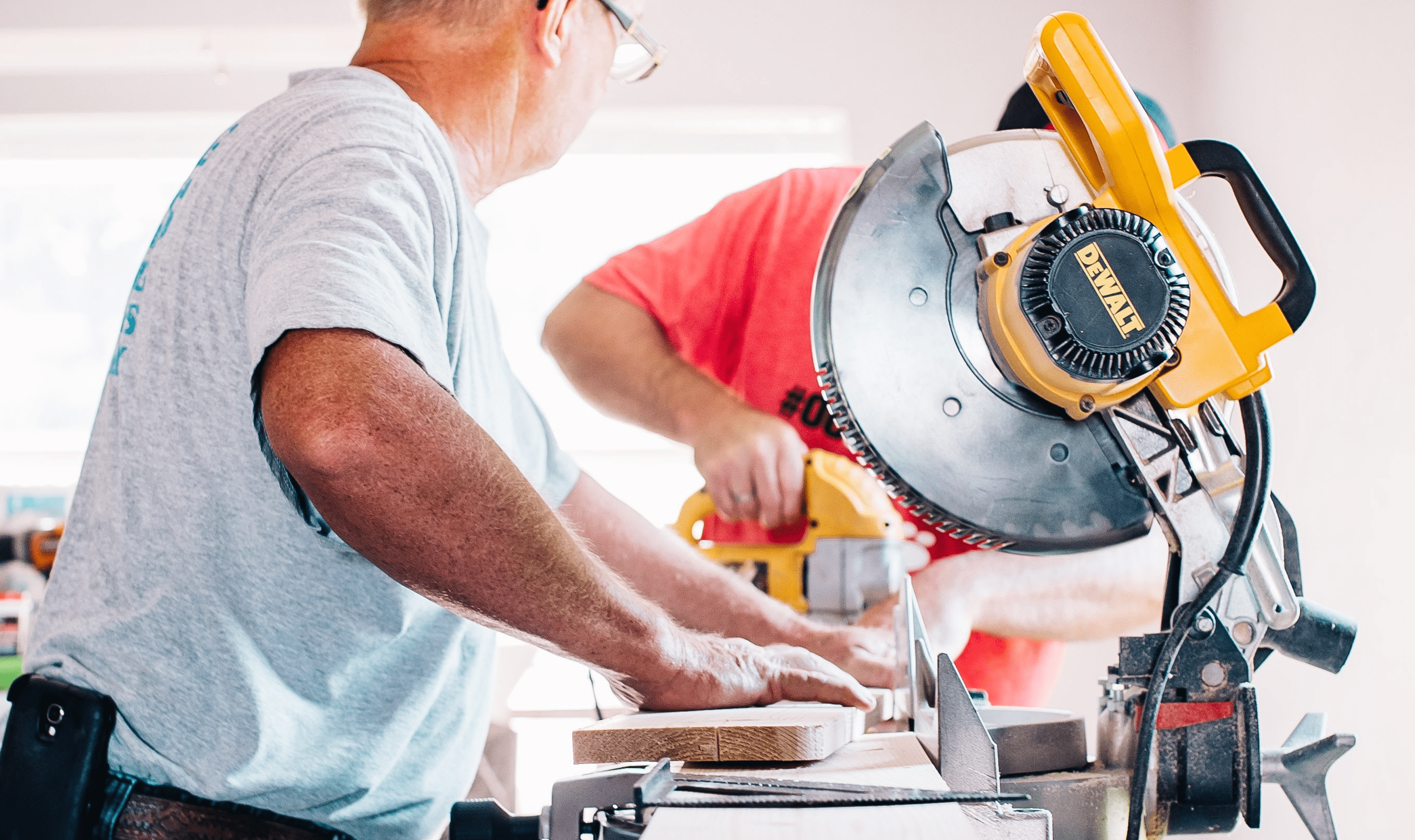 Two men sawing and drilling wood in a pharmacy under construction