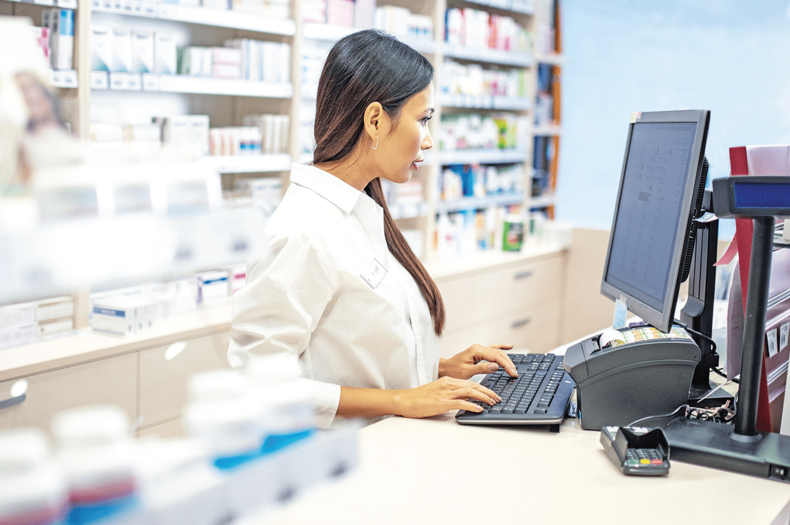 An independent pharmacist ordering prescription medications on a desktop computer
