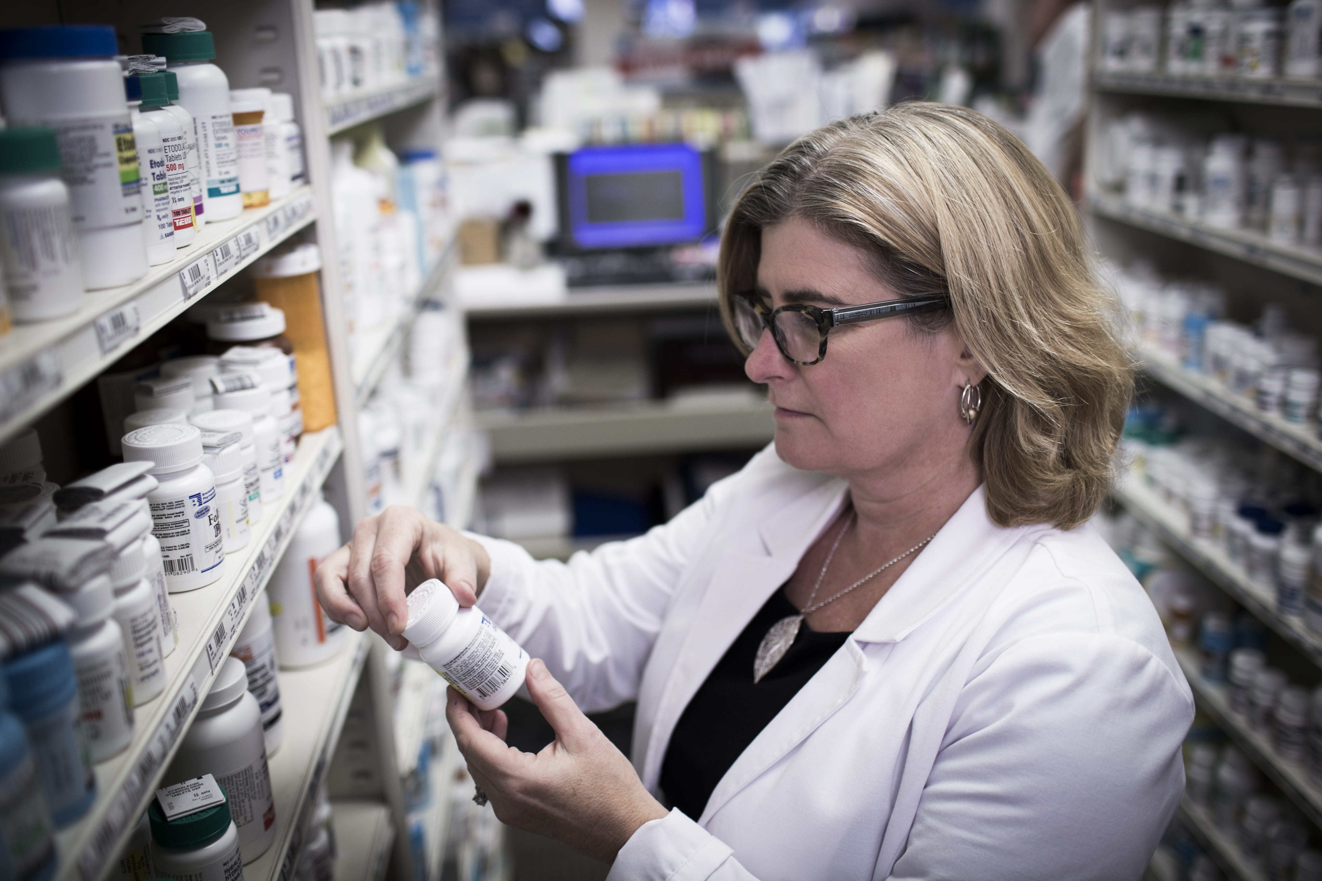 Pharmacist stocking bottles